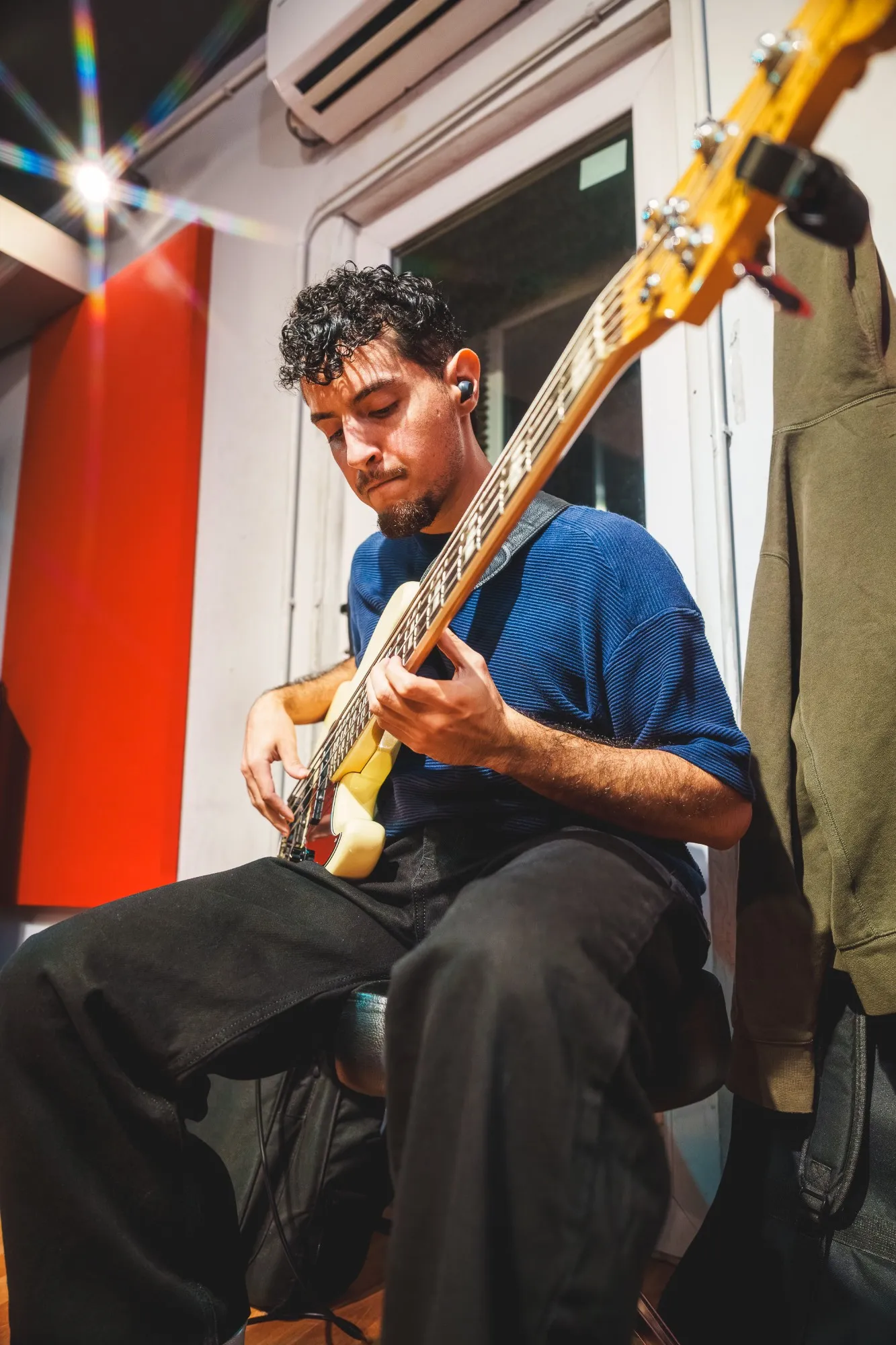 Fabian Canedo tocando el bajo, sentado, en el estudio